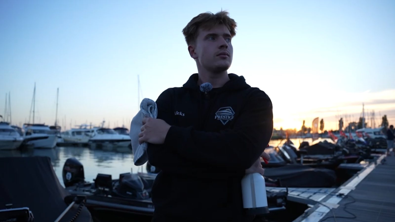 Aleks im Prestige-Hoodie am Hafen bei Sonnenuntergang