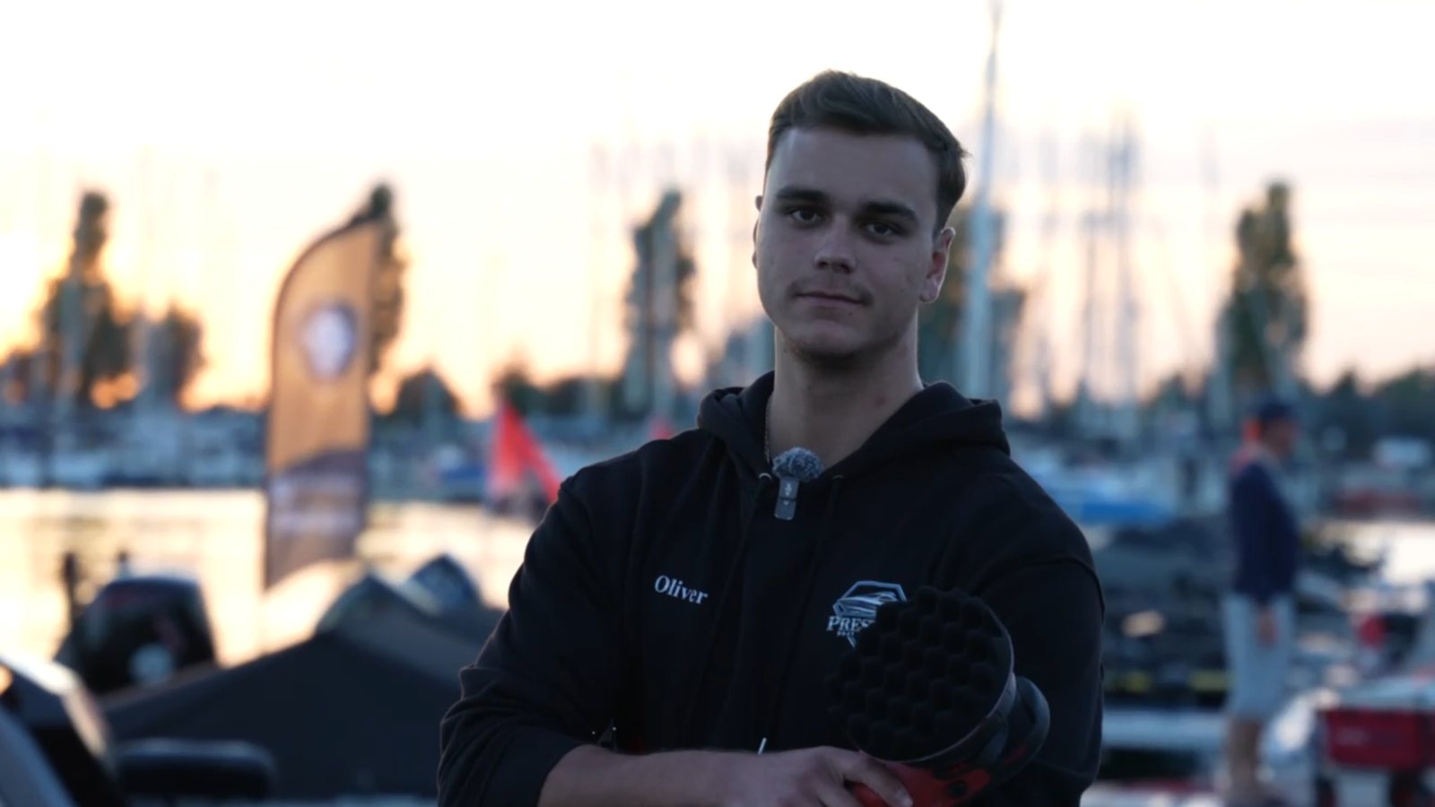 Oli im Prestige-Hoodie am Hafen bei Sonnenuntergang